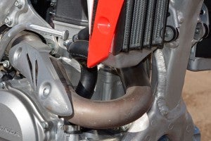 Honda fitted the CRF450R;s 449cc Unicam (SOHC) engine with a new cylinder that features a right-exiting exhaust port. The exhaust header no longer wraps around the chassis' front downtube.