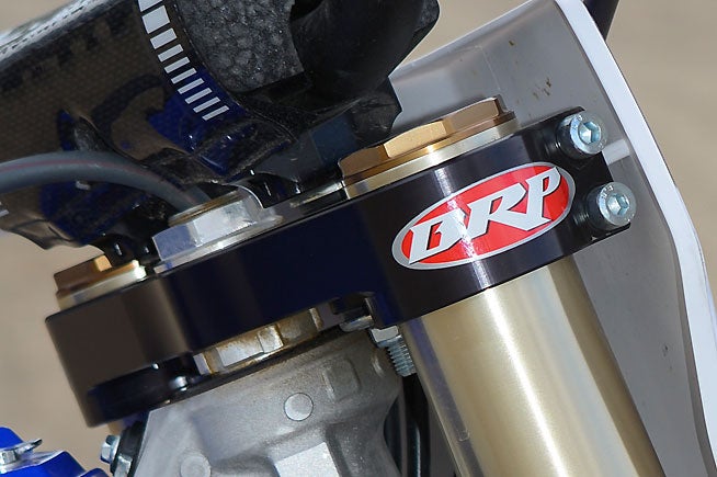 BRP's SX upper fork clamp is strong and offers more ergonomic adjustability than even the Yamaha's stock camp.