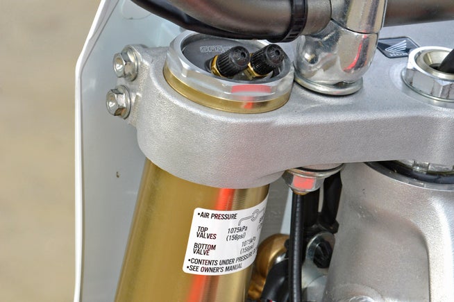 Honda revised the CRF250R’s Showa SFF TAC air fork for 2016 by adding a third adjustment valve (second up top) to allow adjustment of the Outer Chamber pressure. Redesigned fork seals reduce friction as the fork goes through its stroke. The outer fork legs are also 5mm longer to allow the rider one more steering/stability adjustment by moving them up or down in the triple clamps.