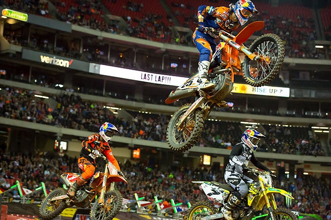 The Conroversy: Race leader Marvin Musquin (25) makes his fateful leap past lapper James Stewart (7) at the Atlanta Supercross while Ryan Dungey (1) runs in second place. PHOTO BY RICH SHEPHERD.