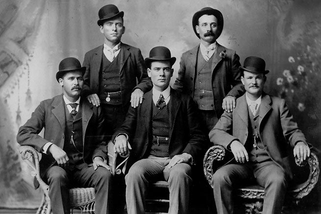 The Wild Bunch was a notorious outlaw band of robbers that operated from 1899 to 1901. The gang included (front row left to right) Harry A. Longabaugh, alias the Sundance Kid; Ben Kilpatrick, alias the Tall Texan; Robert Leroy Parker, alias Butch Cassidy; (standing, left to right) Will Carver, alias News Carver, and Harvey Logan, alias Kid Curry. PHOTO COURTESY OF OUTLAW TRAILS DUAL SPORT ADVENTURES. 