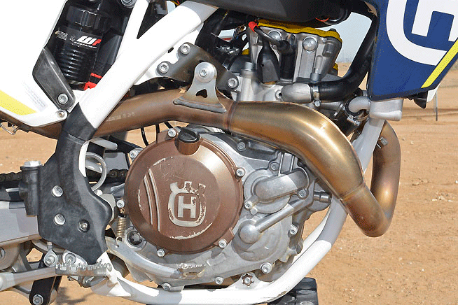 The 2016 HC450's all-new SOHC engine is smaller and lighter than the previous version as well as being more powerful. Note the unique exhaust header shape, which draws from two-stroke expansion chamber theory to produce more power while also being quieter.