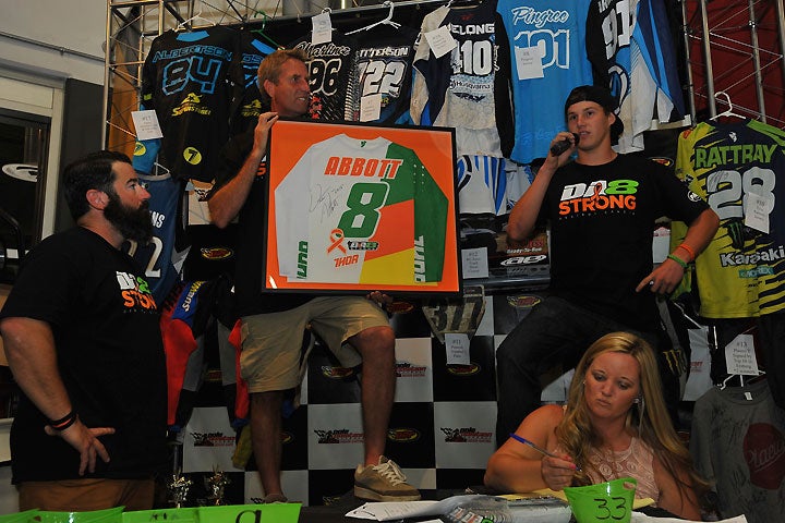 Cooper Abbott (right) explains the special jersey that THOR created for the Destry Abbott Leukemia Fundraiser Event, which was held at Pole Position Raceway in Corona, California. Signed by Destry Abbott and mounted, it topped the evening’s auction items, going for $4500. PHOTO BY MARK KARIYA.