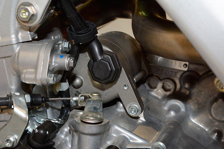 The electric starter motor is mounted right behind the cylinder while the battery is located in the airbox.