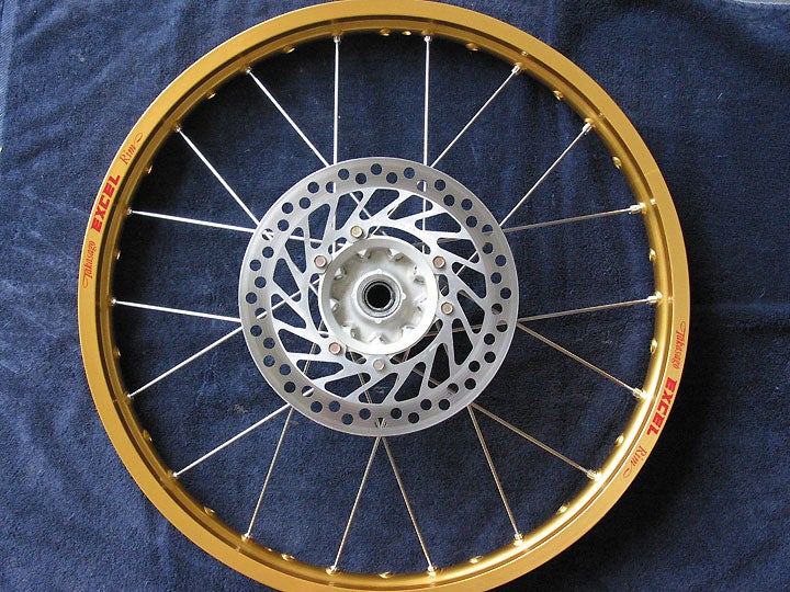 Detail of the spokes leaving the hub.  Notice how the holes point only partway toward the spoke’s target on the rim; the spoke’s bend (right at the hole’s edge) completes the necessary angle.