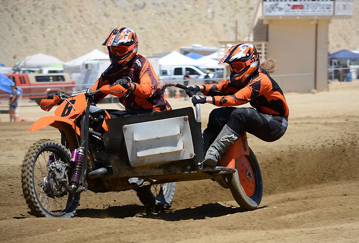 Passenger Kathy Wood demonstrates the technique of a seasoned sidecarcross passenger. There's a lot more to it than just hanging off in the corners. Sidecar passengers exert tremendous influence on the overall handling of the rig on straightaways and over jumps as well.