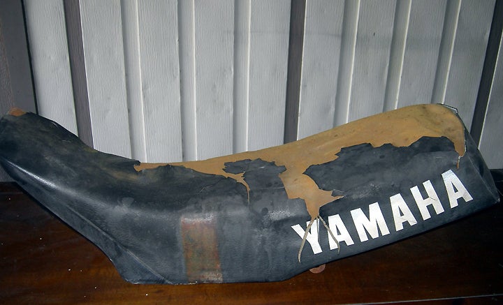 Like most of our past Project Lowbucks machines, the saddle cover on our 1982 Yamaha YZ125 was wasted. The thin layer of cowhide is one of the first things to deteriorate on an old bike, especially when it is left unprotected by the elements.